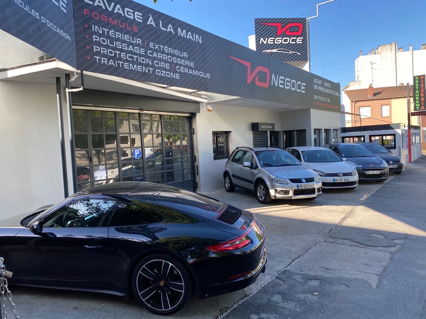 Devanture du showroom V.O Negoce au 38 Av. Aristide Briand, véhicules d’occasion alignés devant